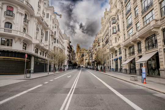 Calle Gran V&iacute;a de Madrid vac&iacute;a bajo un cielo tormentoso, arquitectura cl&aacute;sica europea