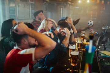 Disappointed fans reacting to team losing in bar