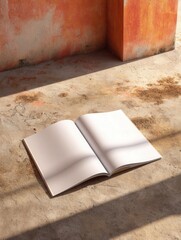 Open notebook resting on sunlit concrete floor beside warm orange walls