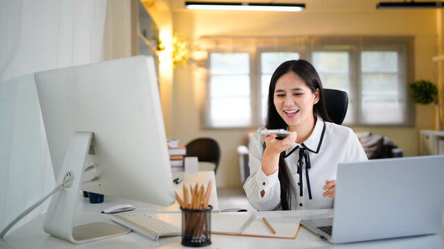 woman recording audio message, businesswoman using online communication app on phone, using voice recorder on phone inside office