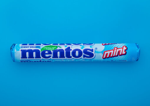 LONDON, UK - JANUARY 25, 2024: Mentos original mint chewy dragees candies on blue background.