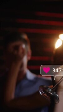 Vertical video: Hand holding flute raising in bar, group toasting causing social updates near glass