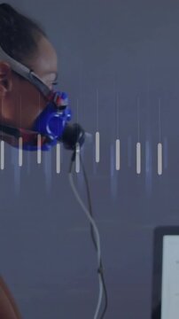 Vertical video: Woman breathing through blue mask driving animated orange line, bars for lab test