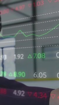 Vertical video: Athlete lifting arm revealing while training in gym with finance chart tracing arm