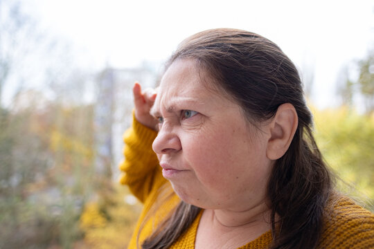 Furious woman staring aggressively, Middle-aged woman making disgusted face outdoors, Facial expression of discomfort, surprise, or awkward social situation, negative social situation
