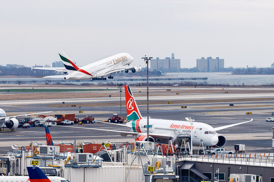 Emirates Airbus A380 passenger aircraft taking off from JFK Airport with Kenya Airways Boeing 787 at gate, New York
