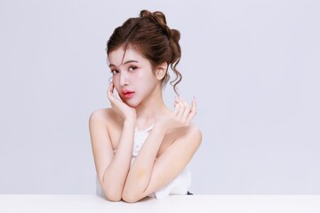 Obraz premium Young Asian Beauty Woman with Natural Makeup and Perfect Glowing Skin Beauty Portrait on Clean Studio Background.