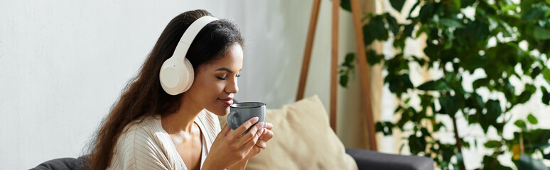 Relaxing moments of a beautiful woman enjoying tea while listening to music at home