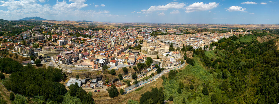 Panoramic aerial view of the city of Venosa, located in the province of Potenza, Basilicata, Italy. Italian town nestled between lush green forests. The urban center features a dense tapestry roofs.