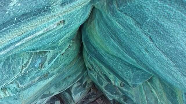 Gaze upon captivating blue and gray swirling marble walls inside Patagonia's Marble Caves. Smooth, water-carved patterns create ethereal, dreamlike atmosphere, testament to nature's artistry.