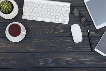 Fototapeta premium Modern workplace with smartphone and keyboard copy space on wood background. Top view. coffee cup.