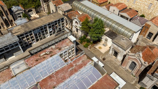Aerial view of a Italian cemetery featuring rows of tombs and loculi. The architectural layout reflects solemn traditions, combining modern and historical burial structures in a quiet city of the dead
