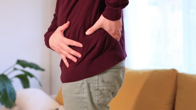 Man with hip, back, spine and sciatica pain at home.