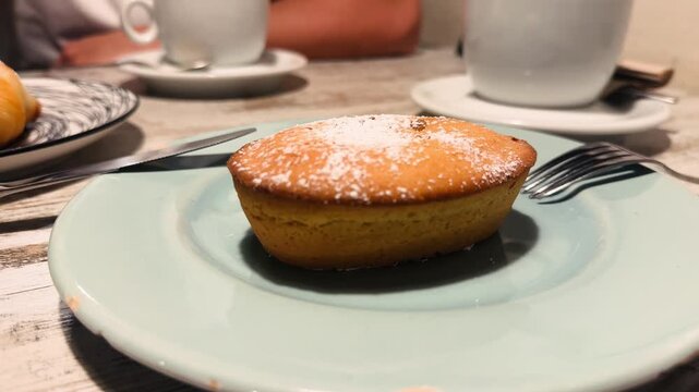 Pasticciotto salentino is a traditional Italian pastry made from shortcrust dough with a sweet filling. Served on a plate in an Italian cafe.