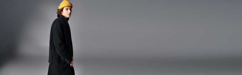 Stylish man in a fashionable coat and bright beanie walks confidently in a sleek environment