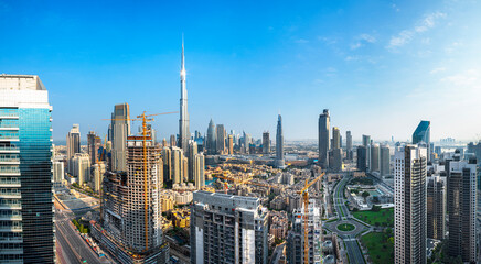 Obraz premium Panoramic skyline of Dubai with modern skyscrapers and futuristic architecture at sunset. Iconic cityscape of the largest city in the United Arab Emirates, famous for luxury tourism, business district