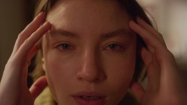 Close up portrait shot of anxious young adult woman closing eyes experiencing trauma flashbacks indoors while light flashes, camera shake effect