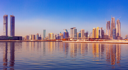 Obraz premium Panoramic skyline of Dubai with modern skyscrapers and futuristic architecture at sunset. Iconic cityscape of the largest city in the United Arab Emirates, famous for luxury tourism, business district