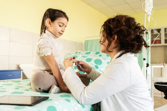The doctor listens to the child&rsquo;s lungs with a stethoscope, then gently prepares them for a vaccine. The scene feels calm and caring, focused on the child&rsquo;s comfort and health.	
