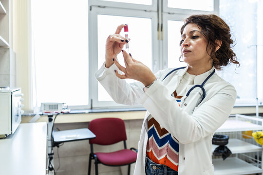 Doctor prepare vaccines in a treatment lab, working carefully with medical equipment. The scene feels sterile and focused, highlighting precision work.