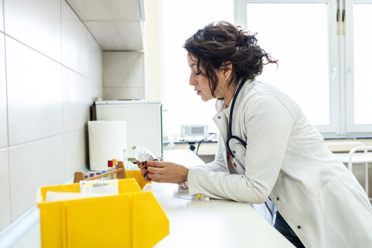 Doctor prepare vaccines in a treatment lab, working carefully with medical equipment. The scene feels sterile and focused, highlighting precision work.	
