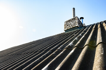 Naklejka premium Chimney pipe from stainless steel on the roof of the house. Repair of roof chimney, brickwork.