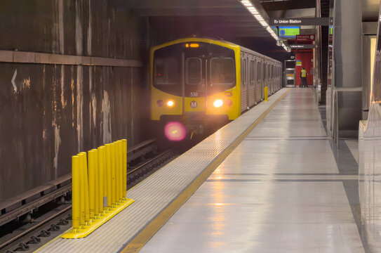 LOS ANGELES, CA, NOV 8, 2025: LA Metro B Line train with yellow front and details, approaches subway station platform, headlights glowing, sign reading "To Union Station."