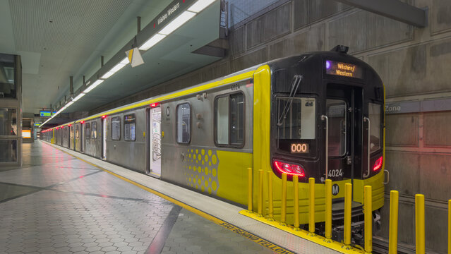LOS ANGELES, CA, NOV 9, 2025: LA Metro D Line train with yellow front and details, stopped at Wilshire-Western subway station platform, headlights glowing, open doors, and sign reading "Wilshire Weste