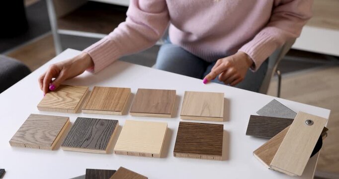 woman choosing furniture and flooring materials from samples at interior design studio