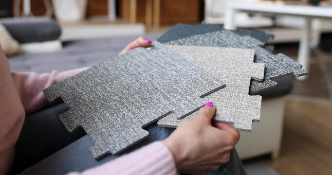 woman choosing vinyl flooring tiles from samples in interior design studio