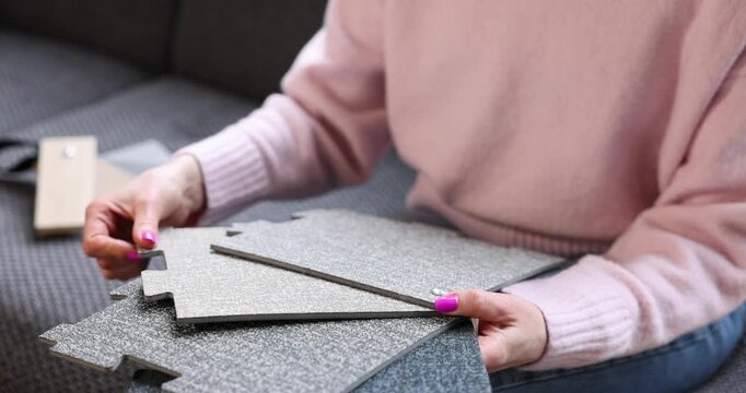 woman choosing vinyl flooring tiles from samples in interior design studio
