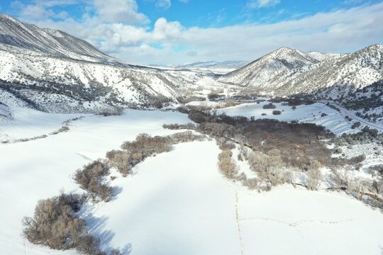 Aerial view of Grass Valley and Grand Hogback mountain ridge near New Castle, Colorado on sunny winter day after heavy snowfall.
