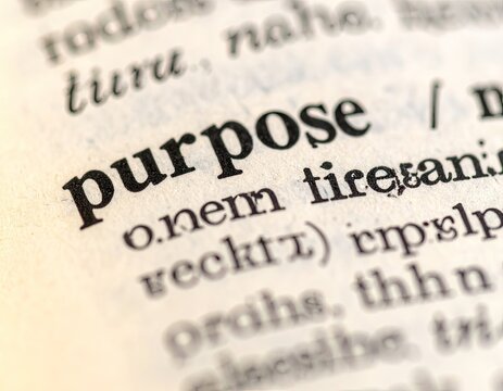 A close-up shot reveals the word 'purpose' highlighted within the pages of an old, possibly Latin or ancient language, dictionary, suggesting a focus on meaning and intent.