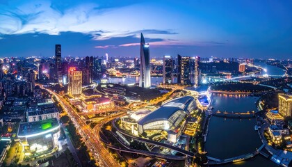 Obraz premium Panoramic view of a modern city skyline at dusk with illuminated buildings and busy highways.