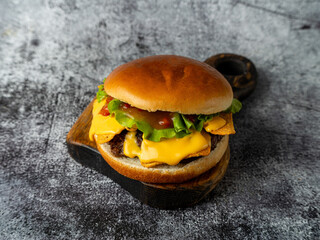 Dessert is served in a clear glass. The layers include fruit, cream, and granola. A mint leaf decorates the top. The setting has a dark backdrop that highlights the dessert © Tkachenko Alexey