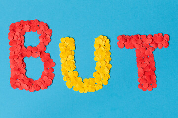 Text goal in French formed with red and yellow confetti on a blue background, concept of an international soccer goal © Andres Serna