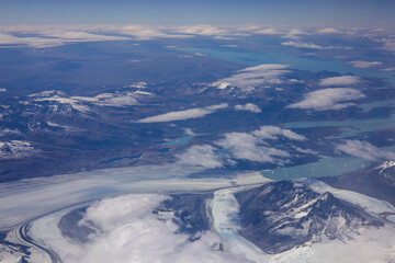 Aerial view from plane of snow-capped mountains and glaciers.