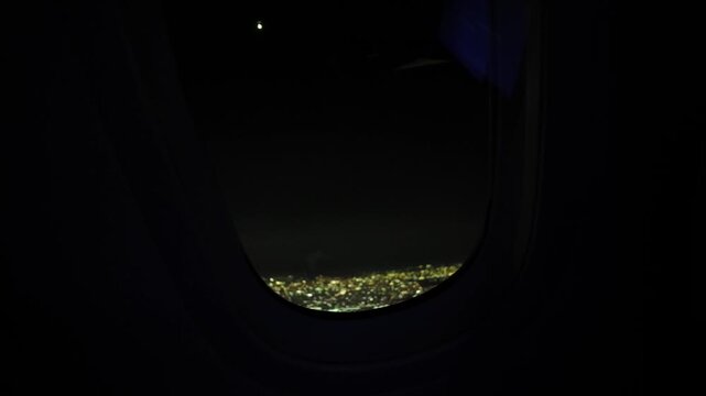 Aerial Night City Lights Seen from Airplane Windo