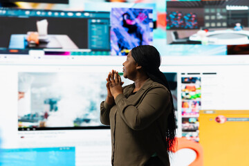 Naklejka premium Woman mesmerized by immersive videowall, amazed by freedom of unlimited video content. User fascinated by virtual space filled with broadcasting channels, social media feeds and multimedia clips