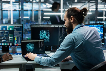 Fototapeta premium Data center software developer running simulations for AI driven forecasting, tracking performance. Server hub IT professional integrating artificial intelligence APIs into software platforms