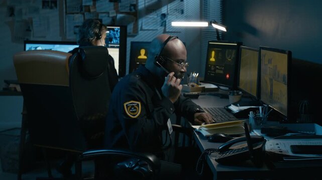 Dramatic shot of Black man working as police dispatcher and taking urgent emergency call at night reacting emotionally to connection breaking, side view