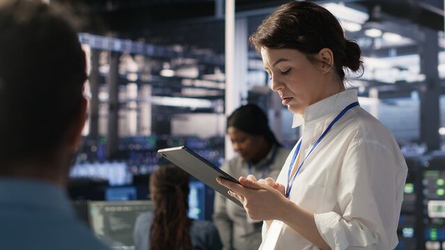 Data center team leader supervising system operations supporting neural networks and analytics workflows. Server hub manager monitoring engineering team managing AI training datasets, camera A
