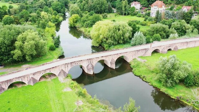 Historische Steinbogenbr&uuml;cke &uuml;ber die Werra: Die Werrabr&uuml;cke in Vacha, bekannt als &bdquo;Br&uuml;cke der Einheit&ldquo;, verbindet Th&uuml;ringen und Hessen und ist ein bedeutendes Denkmal der deutschen Teilung.