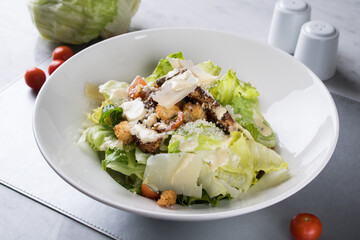 Caesar salad green salad of romaine lettuce and croutons with bread and chicken commonly dressed...