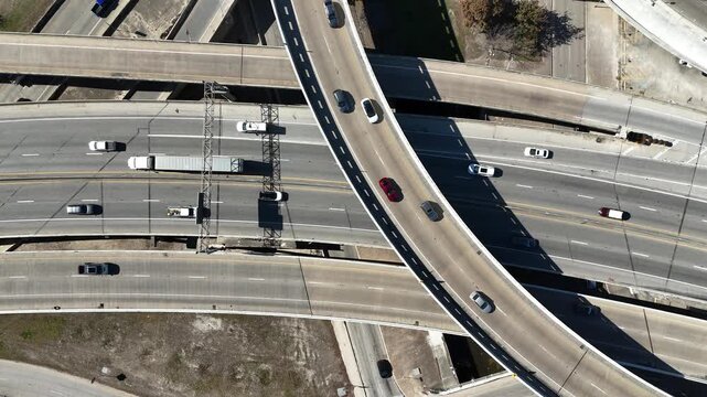 Overhead view of traffic lanes and cars driving on highway interchange 4K Aerial Drone Video