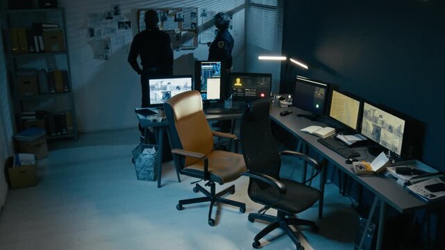 Timelapse shot of two police officers working at police station office during night shift taking emergency calls and planning operations moving around room