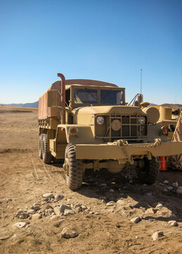 U.S. Army military cargo truck (M939 5-ton) in desert landscape, heavy-duty transport and logistics vehicle in arid terrain under clear blue sky