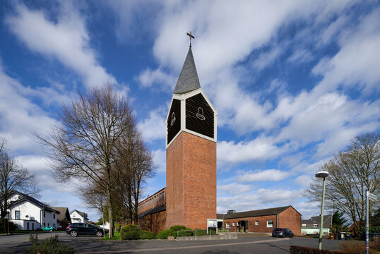 Exterior view of St. Rochus Church in Overath. Significant modern brick architecture with a prominent pyramidal spire in the Bergisches Land