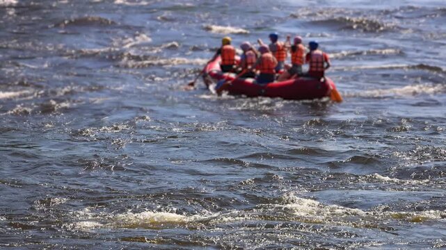 Rafting in whitewater, extreme water sports on water rapids, kayaking and canoeing tour in a mountain river,  water sports team, red and yellow raft boat full of tourists in a summer day, slow motion