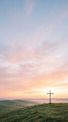 Obraz premium Serene wooden cross standing prominently on a grassy hill during a beautiful pastel sunrise for Christian faith concept and spiritual hope